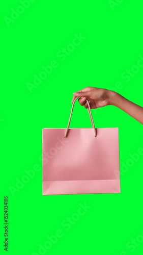Loop vertical video of the female hand holding a shopping bag, alpha channel