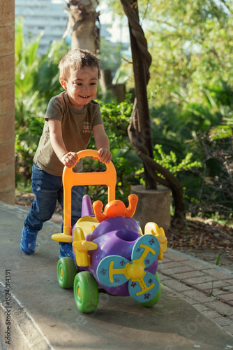 little boy playing with toy car in a park