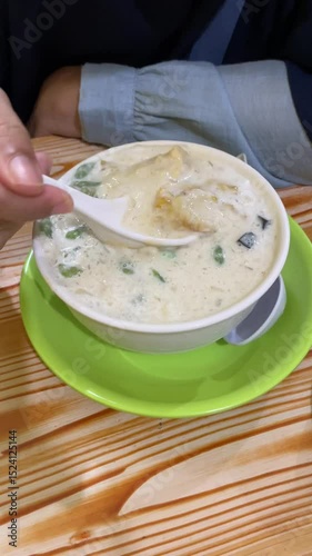 Hand movement stirring ice mix in a bowl on a wooden table