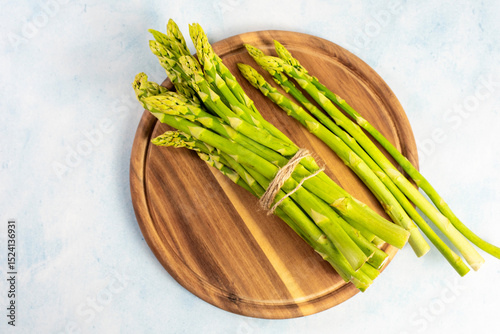 Green Asparagus on a wooden plate