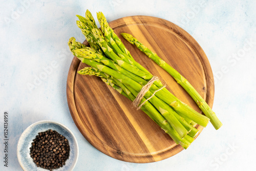 Green Asparagus on a wooden plate