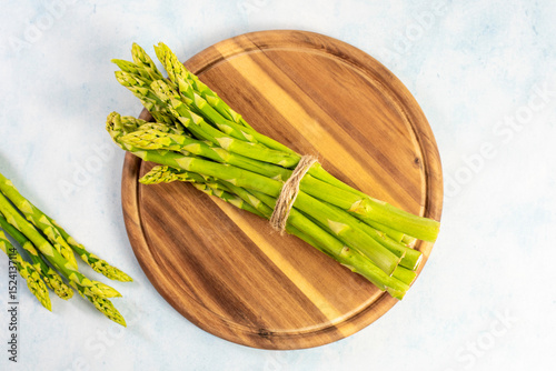 Green Asparagus on a wooden plate