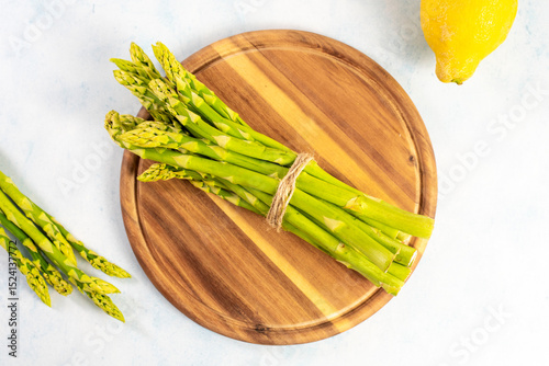 Green Asparagus on a wooden plate