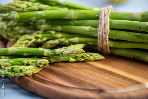 Green Asparagus on a wooden plate