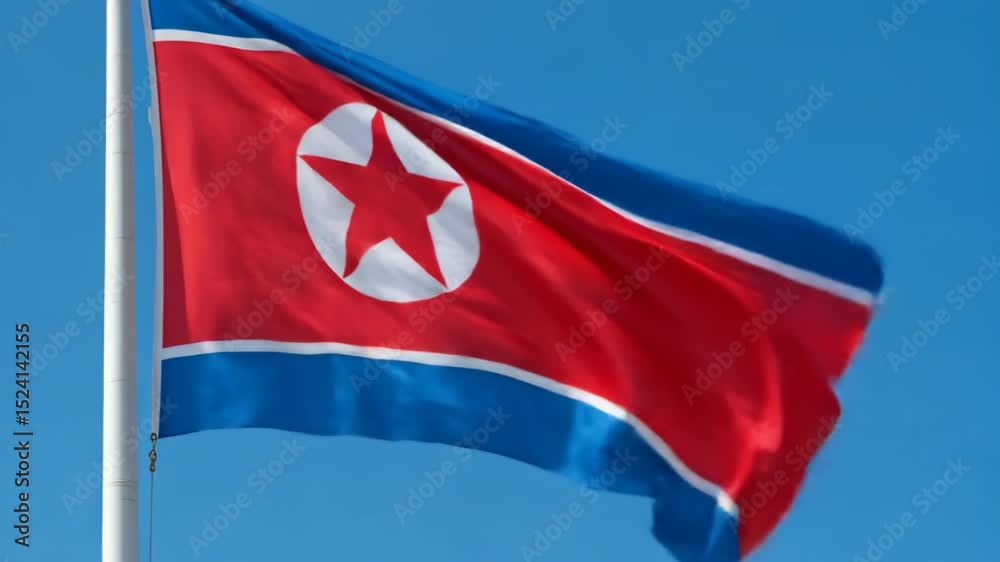 North Korea silk flag waving against a clear blue sky during a bright day. North Korean flag - the national symbol of North Korea, North Korean flag at sunrise