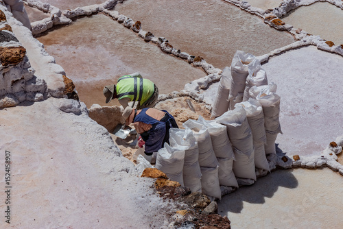 Local people work at Maras salt mines in the Sacred Valley of Incas, Peru