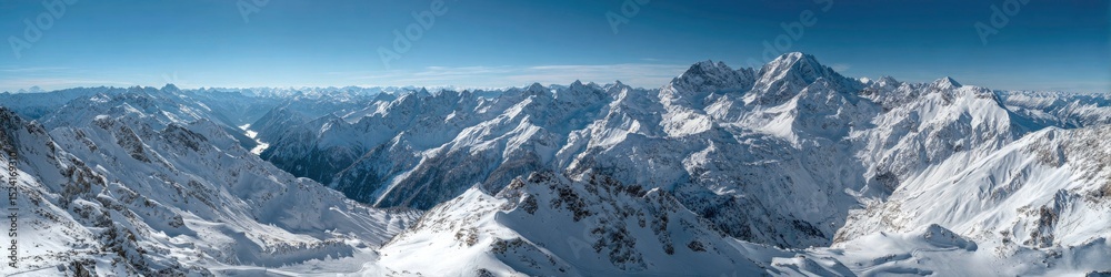 Fototapeta premium Panoramic View of Snow Covered Mountain Range Under a Clear Blue Sky