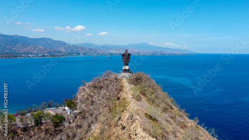 Scenic panoramic aerial view of Cristo Rei landmark statue overlooking blue ocean in capital city Dili, Timor-Leste, Southeast Asia