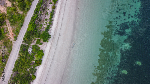 Aerial birds eye view of white sandy beach, crystal clear ocean water, and seaweed farm on Atauro Island, Timor-Leste, Southeast Asia