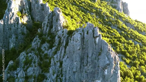 Moving the camera past the mountain top view of the mountains, trees, cliffs and mountain ranges at sunrise