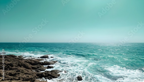 Ocean Waves Crashing on Rocky Coastline Under a Clear Sky