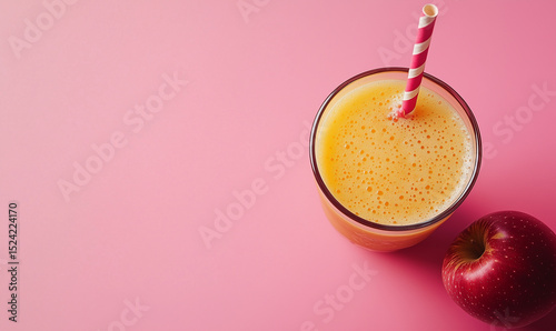 Apple juice with straw isolated on pink background. Summer.