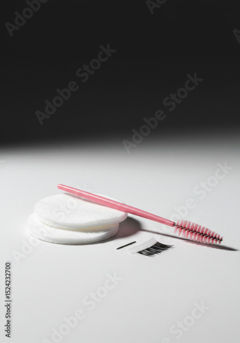 Pink Spoolie Brush with Cotton Pads and False Eyelashes on White Background