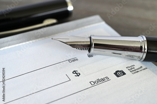 Fountain pen on a blank bank check cheque
