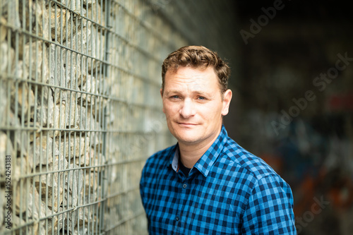 Outdoor portrait of a 46 yo white man wearing a checkered blue shirt, Koekelberg, Belgium