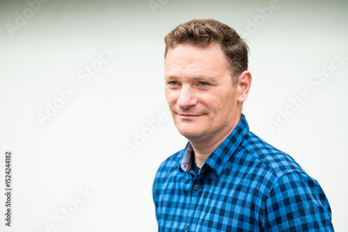Outdoor portrait of a 46 yo white man wearing a checkered blue shirt, Koekelberg, Belgium