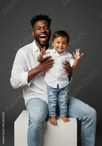 Smiling Father and Toddler Son Posing Together in Matching Outfits