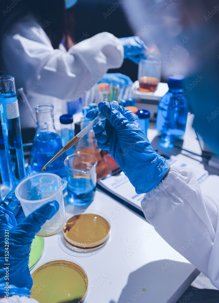 Fototapeta premium Scientist pipetting medical samples into microplate in laboratory
