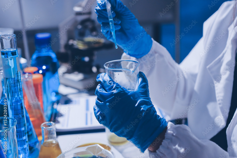 Fototapeta premium Scientist pipetting medical samples into microplate in laboratory
