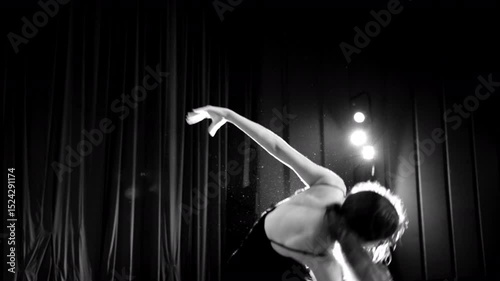 Young talented dancer performing on stage in black and white. Selective focus