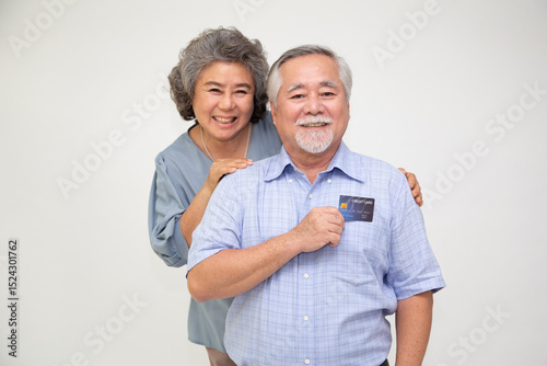 Happy Asian senior couple holding credit card isolated on white background