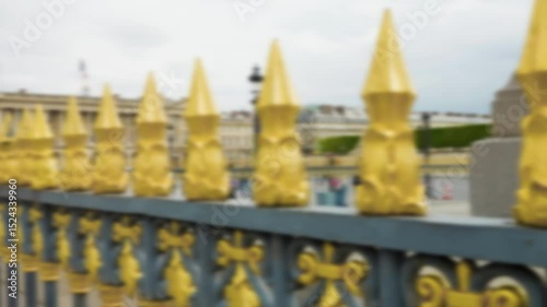 Wrought iron fence painted in gold and black around the Luxor Obelisk, Place de la Concorde. Out of focus. Paris, France.