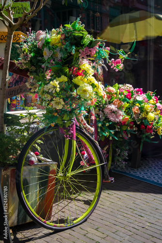 Fototapeta Naklejka Na Ścianę i Meble -  Old vintage woman bicycle decorated with pink flowers on small bridge in old part of Deventer. High quality photo