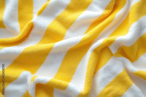 Yellow and White Striped Beach Towel, Yellow and white striped beach towel laid out on sand, perfect for sunbathing or relaxing by the water photo