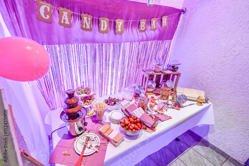 Candy bar pink wedding decorated standing of festive table with deserts, strawberry tartlet and cupcakes