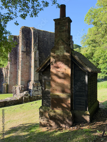 Old brick and timber outbuilding standing beside Furness Abbey’s historic ruins.