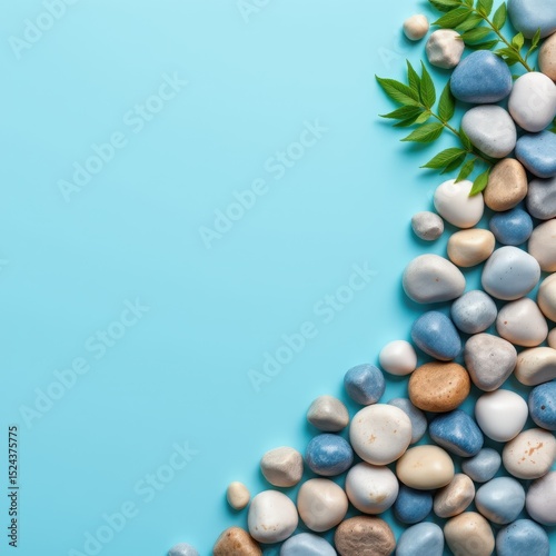 Blue and White Smooth Pebbles with Green Leaves on a Light Background