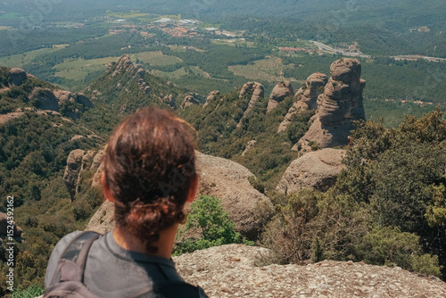 A man with a ponytail contemplating the landscape from the top of the Montserrat mountains (Barcelona)