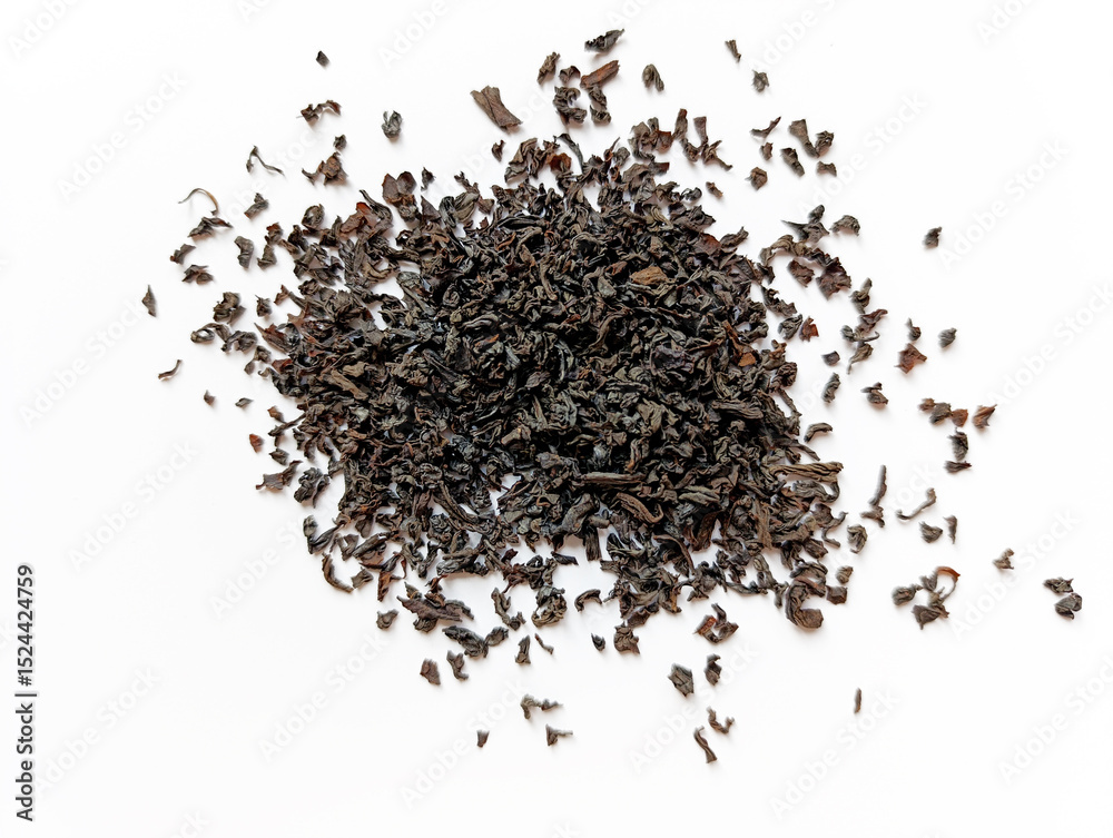 Loose black tea leaves scattered on a white surface showcasing their rich texture and deep color Loose black tea leaves scattered on a white surface showcasing their rich texture and deep color