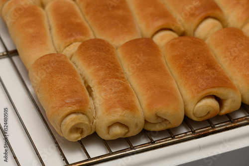 фотографія Freshly baked Parker House rolls with golden crust resting on a wire rack to cool