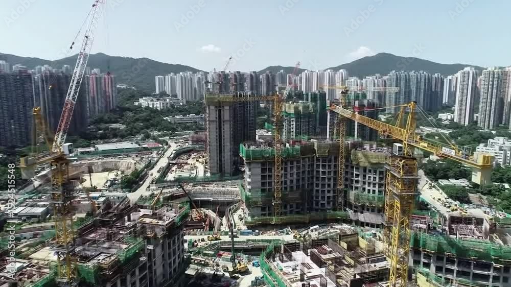 Aerial view of urban construction sites bustling with activity in a cityscape filled with high-rise buildings.