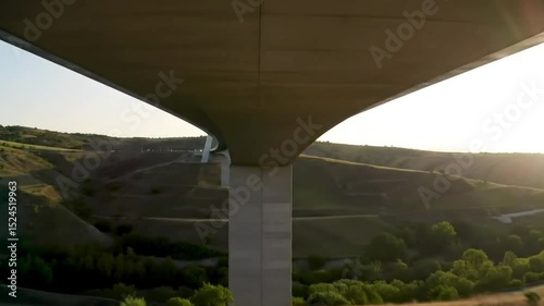 A modern architectural structure with smooth lines and expansive views, set against a backdrop of rolling hills.
