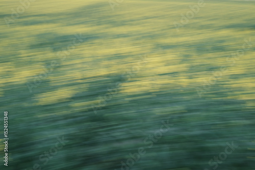 Obraz na plátně A blurry image of a field with grass and water