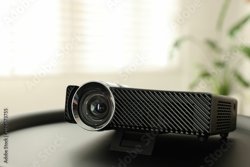 Modern video projector on black table indoors, closeup