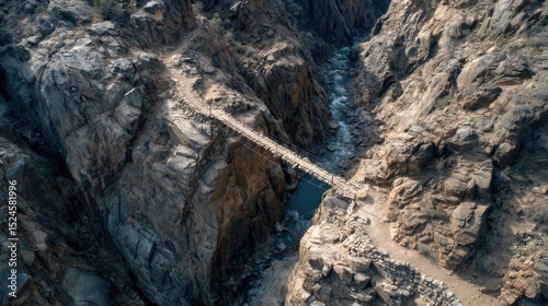 Suspension bridge spans a rugged canyon with a river flowing below
