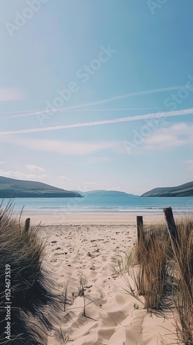 Serene sandy beach with gentle waves under a vast sky, a peaceful escape.
