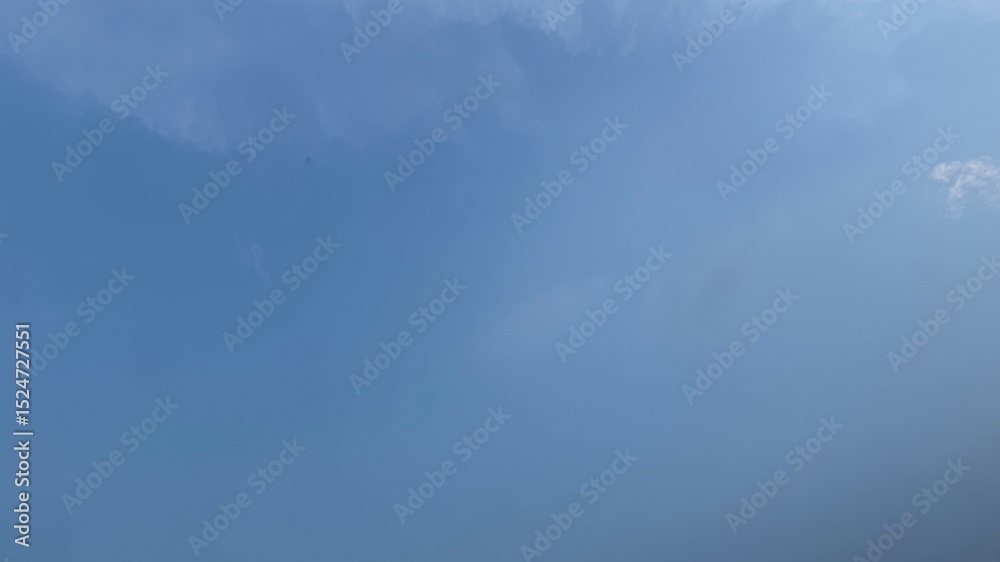 Fototapeta premium Bright Blue Sky with Faint Wisps of Clouds Creating a Soft Atmosphere