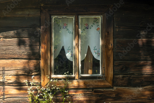 Wooden house window with traditional curtain