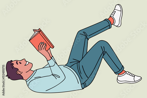 Happy man lying down reading a book