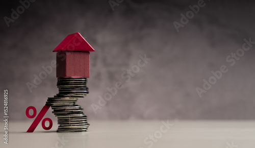 Stacked coins with house and percentage symbol representing mortgage interest rates and real estate investment