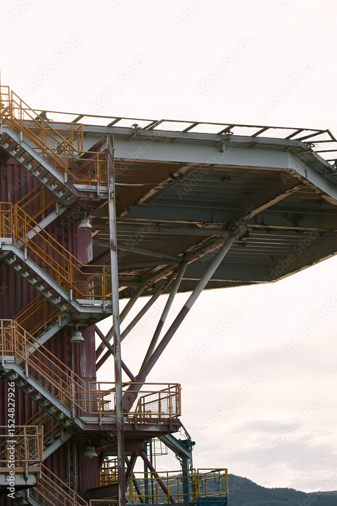 Obraz premium Industrial structure with metal stairs and ocean background