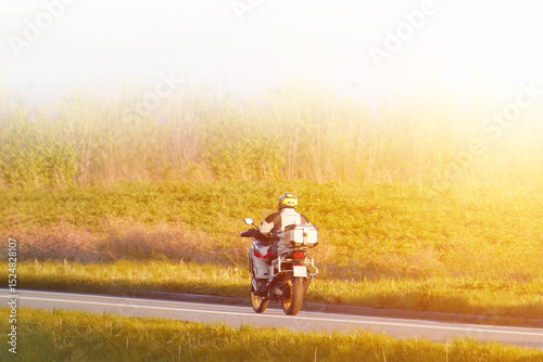 Rider driving away on rural highway