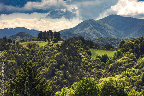 A barn on a green mountain hill in sunny spring day