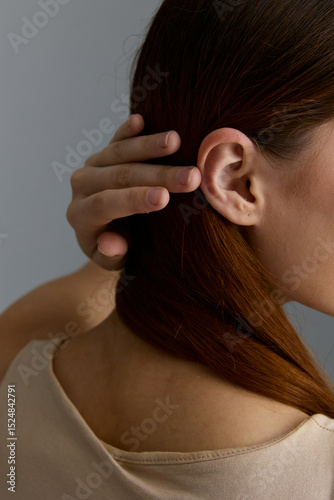Wallpaper Mural Close-up of a beauty woman with red hair gently holding her head, showcasing natural skin and delicate features in soft lighting and neutral background. Torontodigital.ca