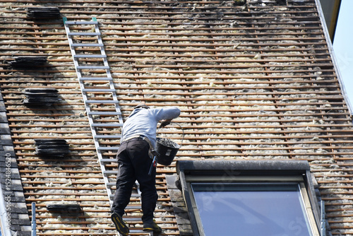 ouvrier couvreur sur un toit d'habitation en rénovation