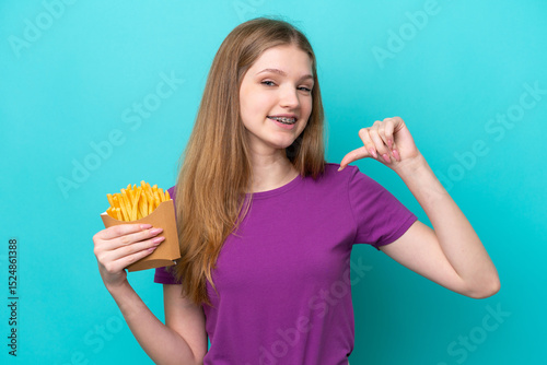 Teenager Russian girl catching french fries isolated on blue background proud and self-satisfied